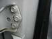 1995 Ford C-350 (Centurion Conversions) - Close-up of a vehicle's door hinge and frame, showing the mounting hardware and a rubber seal.