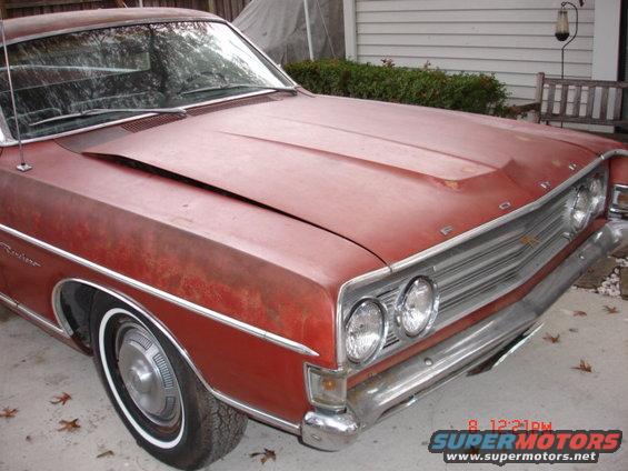 1969 Ford Ranchero front end, red paint with rust spots, chrome grille and bumper