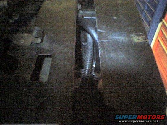 Close-up of a corrugated wiring harness in a dark engine bay