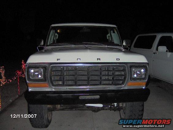 Front view of a 1979 Ford F-150 truck, with another white truck partially visible to the right