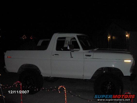 white 1979 Ford Bronco parked at night with Christmas lights