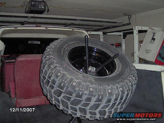 Spare tire mounted inside a vehicle with red seats visible
