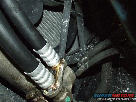 Close-up of oil cooler lines connected to a fitting, with a radiator visible behind