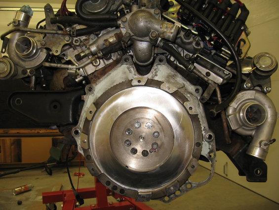 Twin-turbo V6 engine with flywheel visible