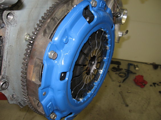 Blue clutch assembly bolted to engine flywheel