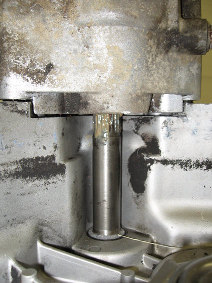 Close-up of a metal shaft protruding from a greasy, weathered engine block