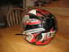 2004 Yamaha RAPTOR 660 - A black, red, and gray flame-patterned helmet sits on a wooden surface.