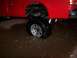 1991 Ford Bronco - A red truck's rear wheel is submerged in muddy water, with the chrome rim partially visible.