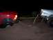 1991 Ford Bronco - Two trucks are stuck in the sand at night, with one attempting to tow the other.