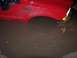 1991 Ford Bronco - A red truck's front fender and tire are partially submerged in a large puddle of muddy water.