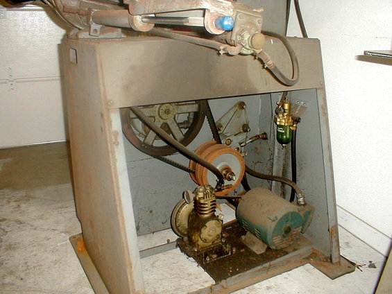 Industrial air compressor with green motor and belt-driven pulleys