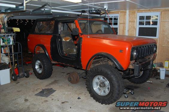 Orange International Scout II in garage, missing front wheel and door panel