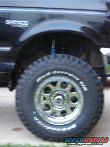 Close-up of a Bronco's front wheel and fender. It has a blue shock absorber visible