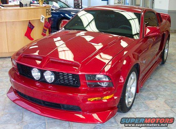 Red 2005 Ford Mustang front quarter view with aftermarket hood scoop
