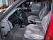 1994 Jeep Grand Cherokee - The interior of a red 1994 Jeep Grand Cherokee features gray velour seats and a dashboard with visible gauges.