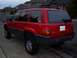 1994 Jeep Grand Cherokee - Rear view of a red 1994 Jeep Grand Cherokee parked curbside.