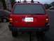 1994 Jeep Grand Cherokee - The rear of a red Jeep Grand Cherokee is shown, its license plate and taillights.
