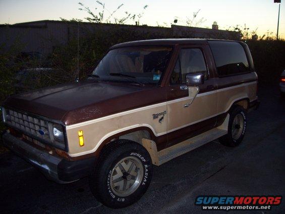 Brown and tan two-door Ford Bronco II with a chrome bumper and aftermarket wheels