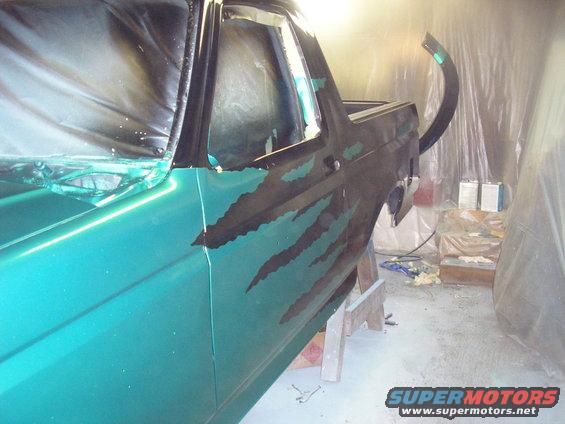 Car door with green and black paint, covered in plastic sheeting