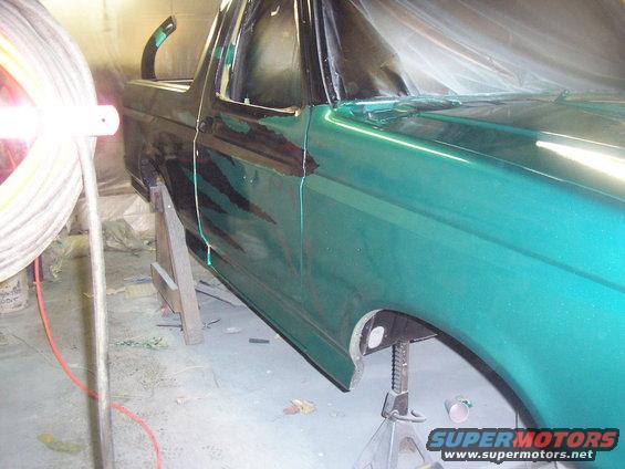 Green SUV side view, undergoing paint repair