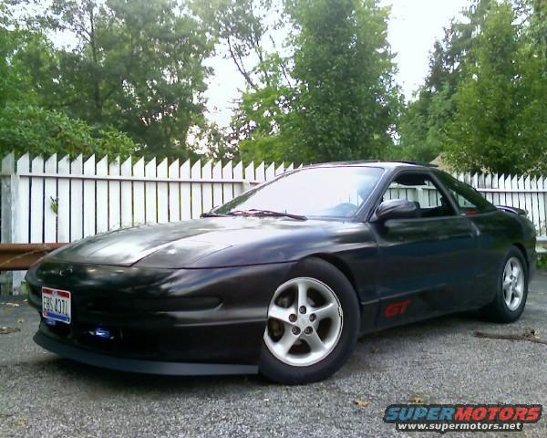 Black 1993 Ford Probe GT parked outside with a white picket fence behind it