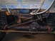 1986 Ford Bronco - The underside of a vehicle shows its drivetrain components and suspension system.