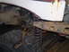 1986 Ford Bronco - The image shows a close-up of a vehicle's undercarriage, focusing on the frame and suspension components.
