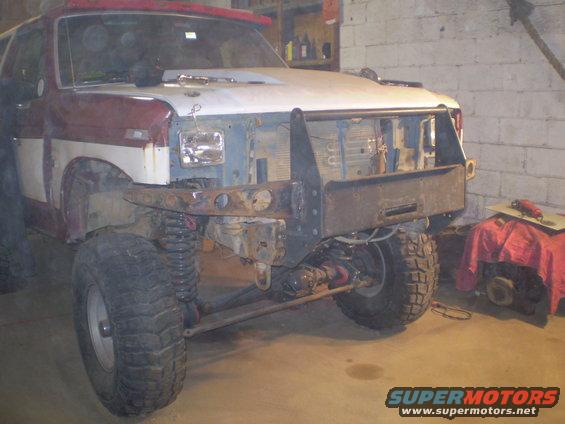 Red and white Ford Bronco, front end removed, aftermarket bumper, lifted suspension