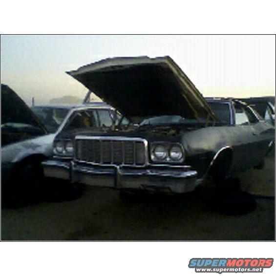 1973 Ford Ranchero front end with hood open, parked in junkyard next to another car