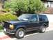 1991 Ford Explorer - This 1991 Ford Explorer is parked on a residential street with a lush green hillside in the background.