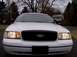 1999 Ford Crown Victoria - Front view of a white 1999 Ford Crown Victoria, its black grille and headlights.