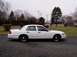 1999 Ford Crown Victoria - Side profile of a white Ford Crown Victoria sedan on a gravel surface with trees and utility poles behind it.