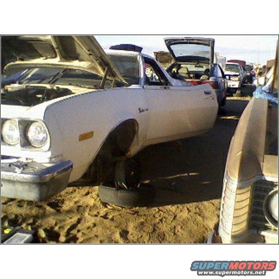 1973 Ford Ranchero with hood and trunk open, missing front wheel, in a junkyard