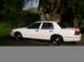 1999 Ford Crown Victoria - A white sedan is parked outdoors with trees in the background.