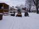 1999 Ford Crown Victoria - Three snowmobiles are parked in the snow next to a wooden gazebo.