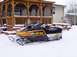 1999 Ford Crown Victoria - A ski-doo snowmobile sits in the snow beside a wooden gazebo on a winter day.