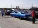 1999 Ford Crown Victoria - A blue 1966 Ford Fairlane coupe is parked at a drag strip with spectators in the background.