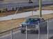 1999 Ford Crown Victoria - A blue 1965 Ford Fairlane sits on the side of a drag strip, with another vehicle in the background.