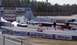1999 Ford Crown Victoria - A drag racing event is underway with cars on the track and spectators in the background.