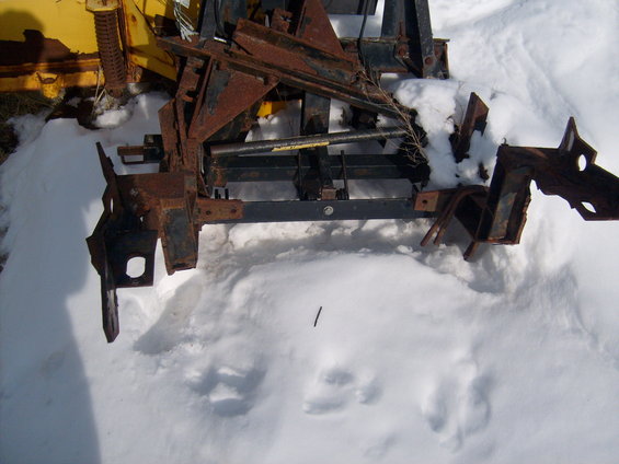 Rusted metal plow mount assembly in snow