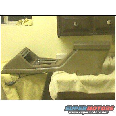 Car center console with shifter mechanism visible, resting on cloth