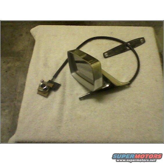 Car side mirror assembly with chrome trim and black backing, resting on a white cloth