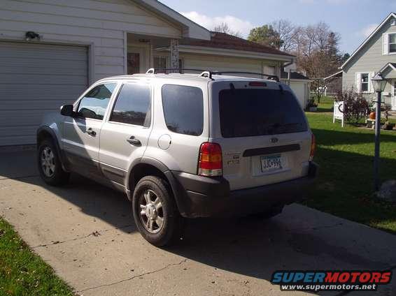 Silver 2002 Ford Escape parked in front of a garage and house