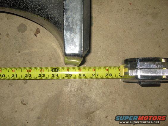 Chrome bumper piece next to a tape measure showing about 26 inches