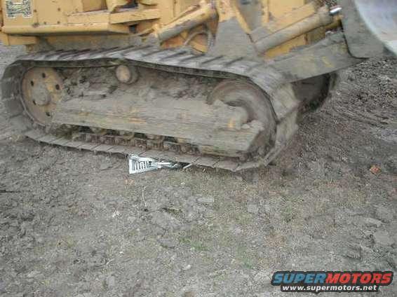 Close-up of a heavy equipment track with mud and debris
