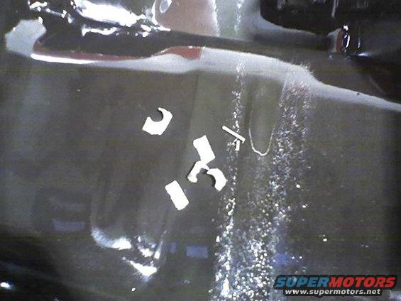 Car floor with white debris and water droplets, Supermotors logo in lower right