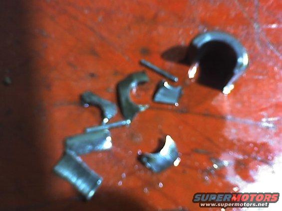 Scattered metal engine parts on a red surface