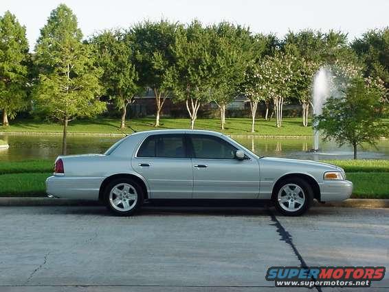 Silver 2002 Ford Crown Victoria sedan parked by a lake, side view
