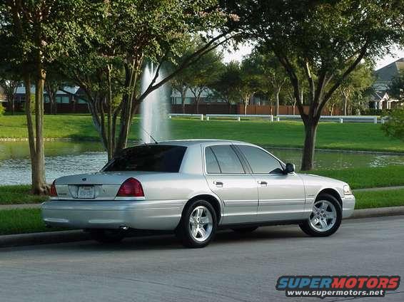 Silver 2002 Ford Crown Victoria parked near a lake with a fountain