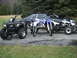 1996 Ford Bronco - A collection of recreational vehicles and a car are parked on a paved surface with grass and trees in the background.
